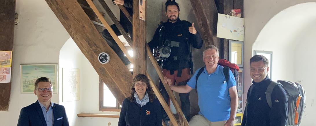 Sechs Personen auf und neben einer Holztreppe