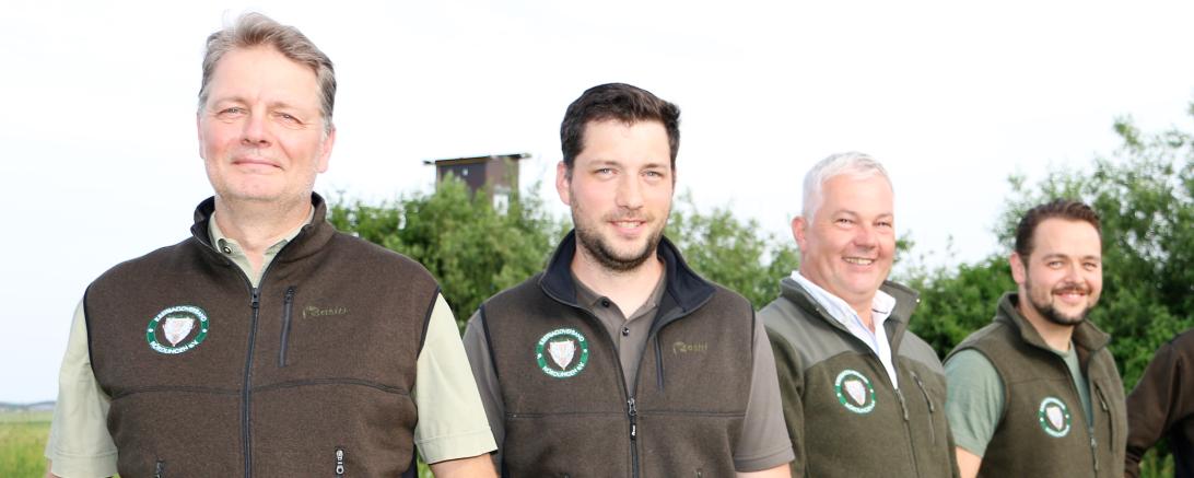 Vier Männer in olivgrünen Westen