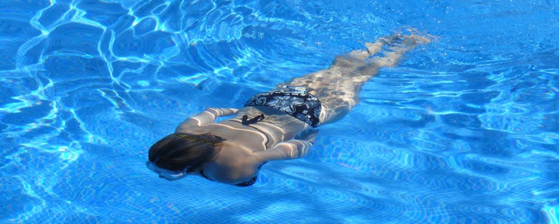 Frau schwimmt unter Wasser