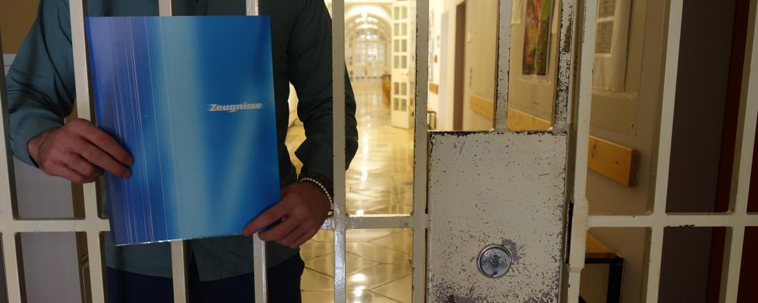 Das Bild zeigt einen Inhaftierten mit Zeugnis.
