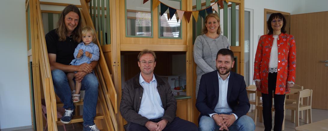 Fünf Erwachsene und ein Kind in Kindergartenraum mit Spiellandschaft