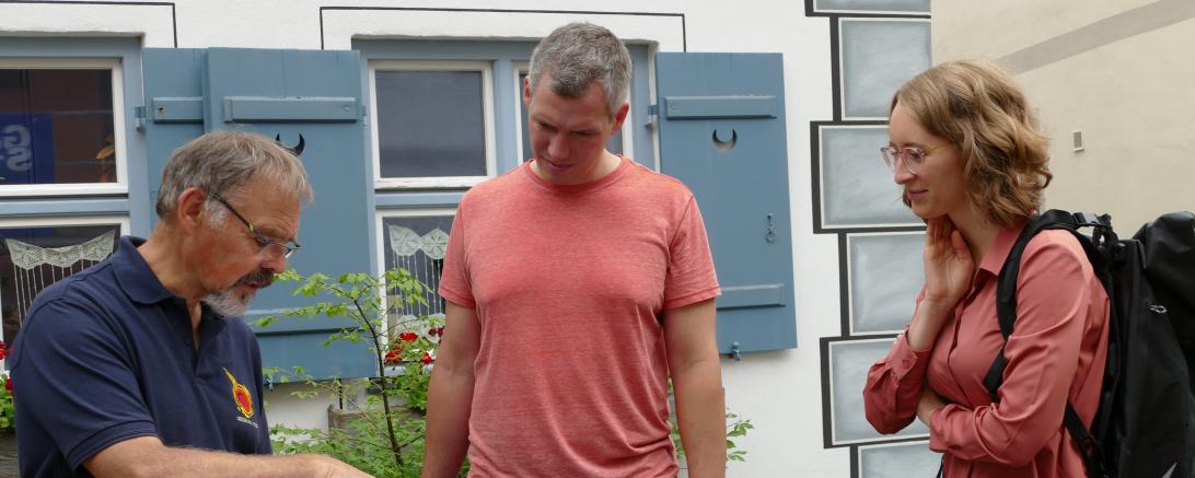 Anhand alter Zeichnungen veranschaulichte  Geoparkführer Kurt Kroepelin beim Rundgang mit den Landtagsabgeordneten Christian Zwanziger und Eva Lettenbauer (v.l.) die Entwicklung Nördlingens. 
