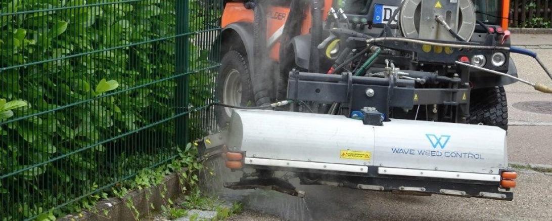 Straßenreinigungsmaschine bekämpft Unkraut mit Heißwasser