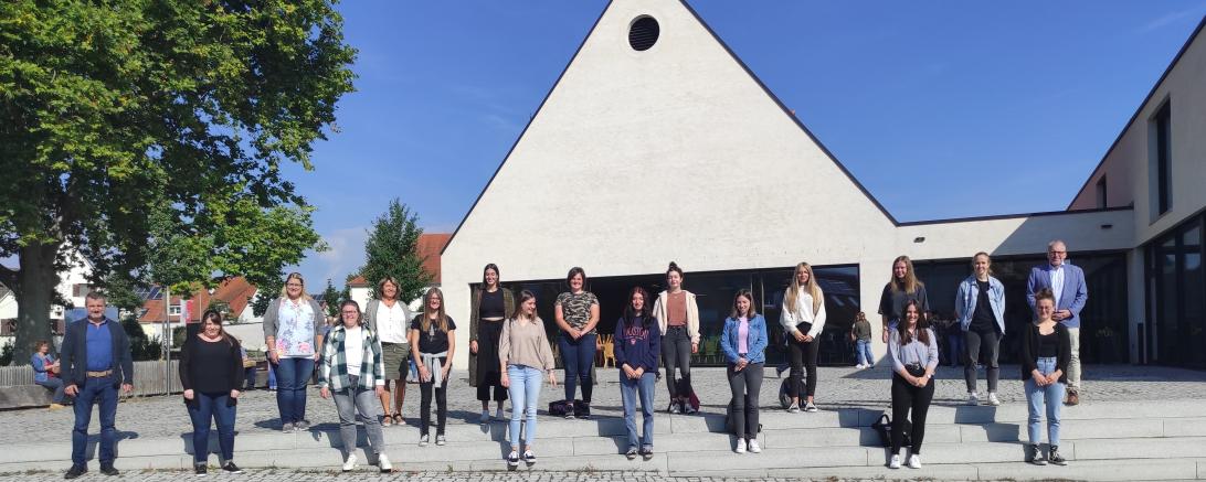 Das Bild zeigt ganz links Timm Albert, Leitung HPT, daneben Carolin Offinger, übergreifende Anleitung, hintere Reihe ganz links Jeanette Zeuß, stellv. Leitung HPT und Gabriele Allgayer-Pfaff,  Fachbereichsleitung, die Freiwilligendienstleistenden und Praktikantinnen und den stellv. Geschäftsführer der Lebenshilfe, Manfred Steger (ganz rechts).