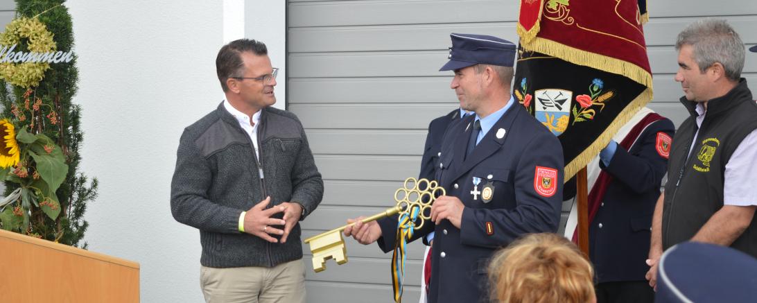 Donauwörths Oberbürgermeister Jürgen Sorre übergibt Schäfstalls Feuerwehrkommandant Ulrich Reitschuster symbolisch den "Goldenen Schüssel" zur Eröffnung des neuen Feuerwehr - und Gemeindehauses 
