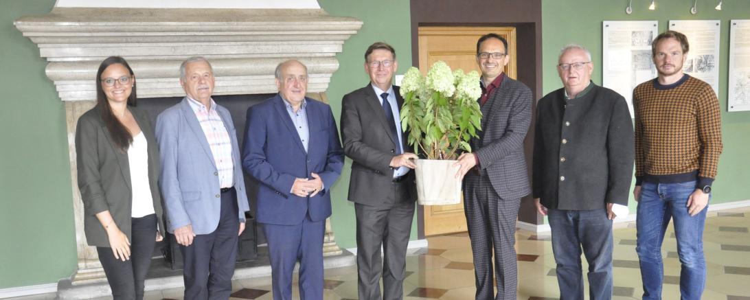 Mit einer Hortensie überraschte Bürgermeister Dr. Martin Drexler Landrat Stefan Rößle. Die Mitglieder des Arbeitskreises (von links:  Judith Strohhofer, Roland Schuster, 3. Bgm. Gottfried Hänsel, 2. Bgm. Johann Roßkopf sowie Johannes Vogel) begleiteten den Bürgermeister.