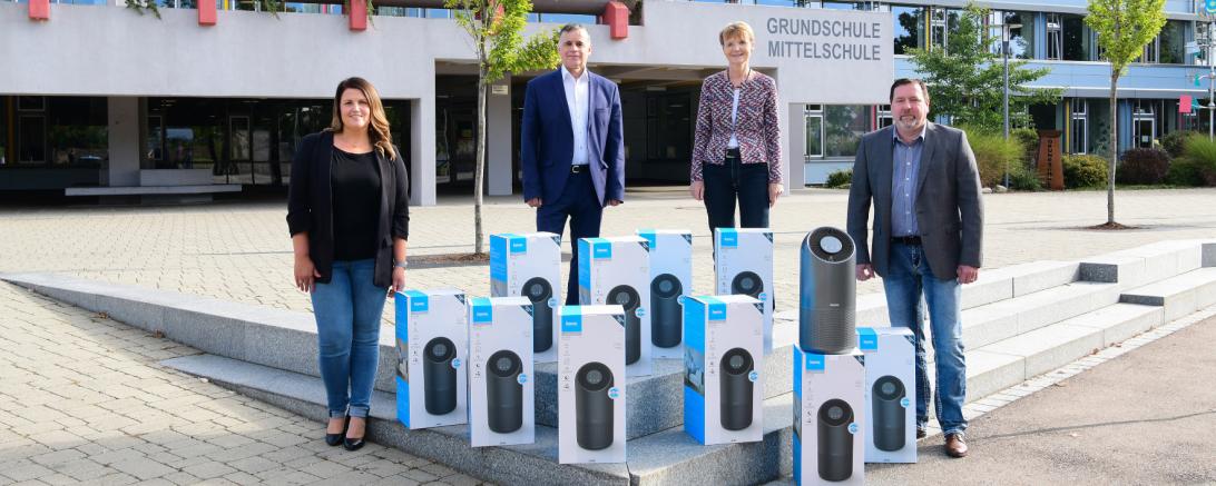 Auf dem Bild sieht man: Barbara Simon (2.v.r..), Rektorin der Grund- und Mittelschule Monheim, Günther Pfefferer (2.v.l.), Bürgermeister der Stadt Monheim und Erwin Bleibinhaus (rechts), Kämmerer in Monheim bei der Übergabe der Luftreiniger durch Christina Schlosser von Hama (links).