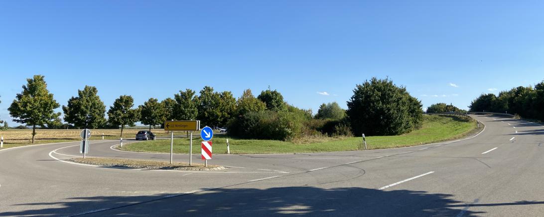 Straßenkreuzung mit Begrünung und Verkehrsschildern