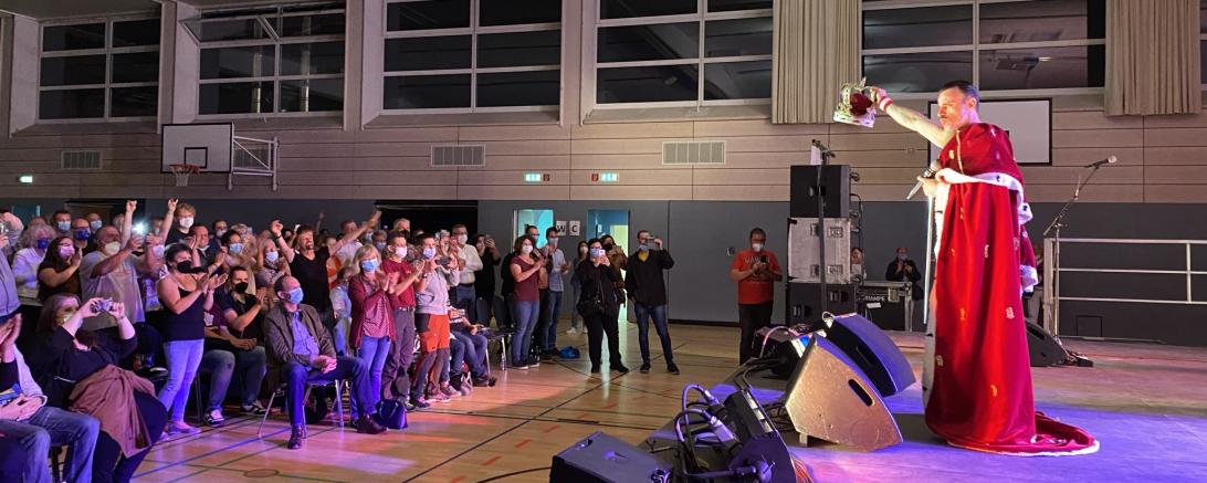 Auf dem Bild zu sehen das begeisterte Publikum und ein Musiker.