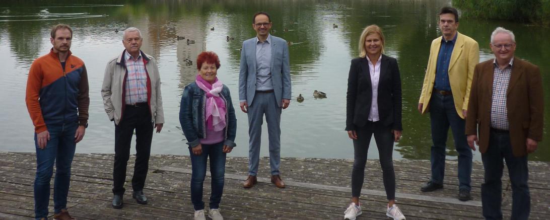 Sieben Personen vor Johannisweiher Wemding, im Hintergrund Stadtpfarrkirche