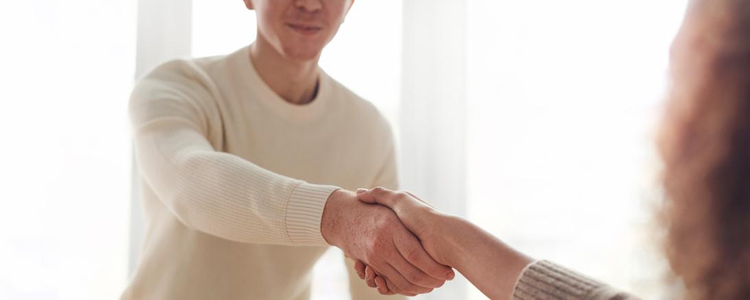 Handschlag über einen Schreibtisch hinweg