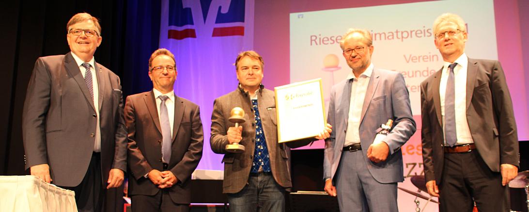Die Preisverleihung an Dr. Oliver Sachs (Mitte), mit Paul W. Ritter (Vorstandsvorsitzender RVB Ries eG, links), Prof. Dr. Markus Glück, (Aufsichtsratsvorsitzender, 2. von links), Prof. Dr. Kai Wünnemann (Laudator, 4. von links) und Bernhard Ströbele (stellvertretender Vorstandsvorsitzender, rechts).