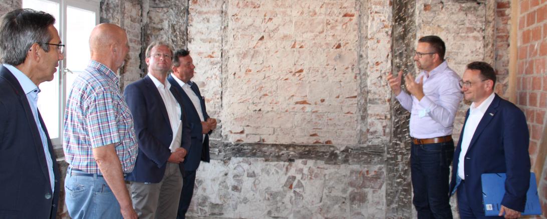 Sechs Personen vor Wand in mittelalterlichem Haus