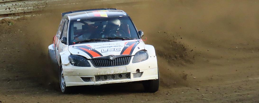 Autocrosswagen driftet über staubige Strecke