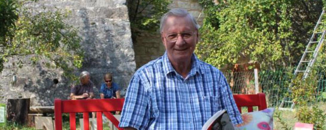 Auf dem Bild sieht man Manfred Hahn mit einem Buch in der Hand. Er wird am 31. Oktober eine Vorlesung im B+ Zentrum Blossenau machen