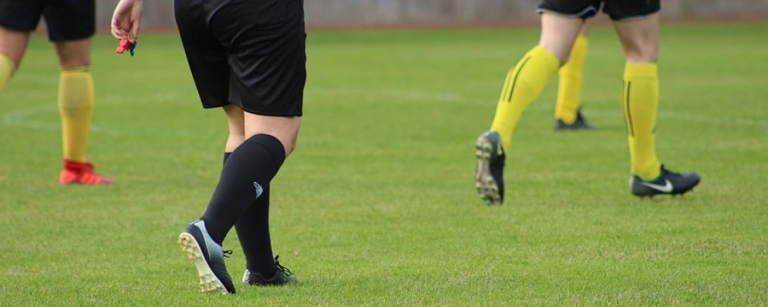 Fußballer und Schiedsrichter auf dem Spielfeld