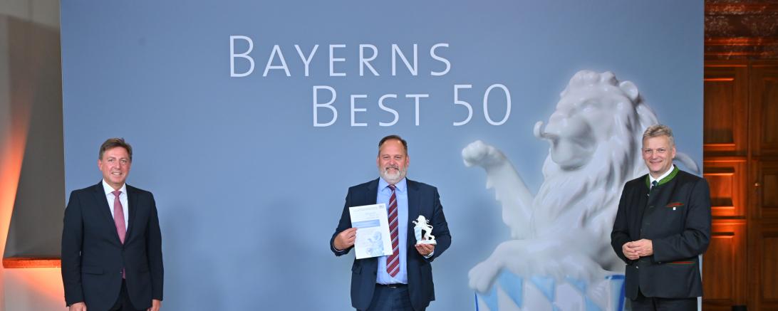 Die Auszeichnung „Bayerns Best 50“ nahm Geschäftsführer Gunnar Bregler (mitte) für die UNSINN Fahrzeugtechnik von Juror Prof. Dr. Thomas Edenhofer (links) sowie von Bayerns Wirtschaftsstaatssekretär Roland Weigert entgegen.