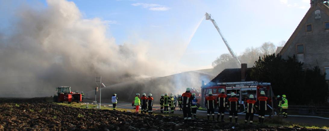 Feuerwehrkräfte beim Löschen einer brennenden Halle