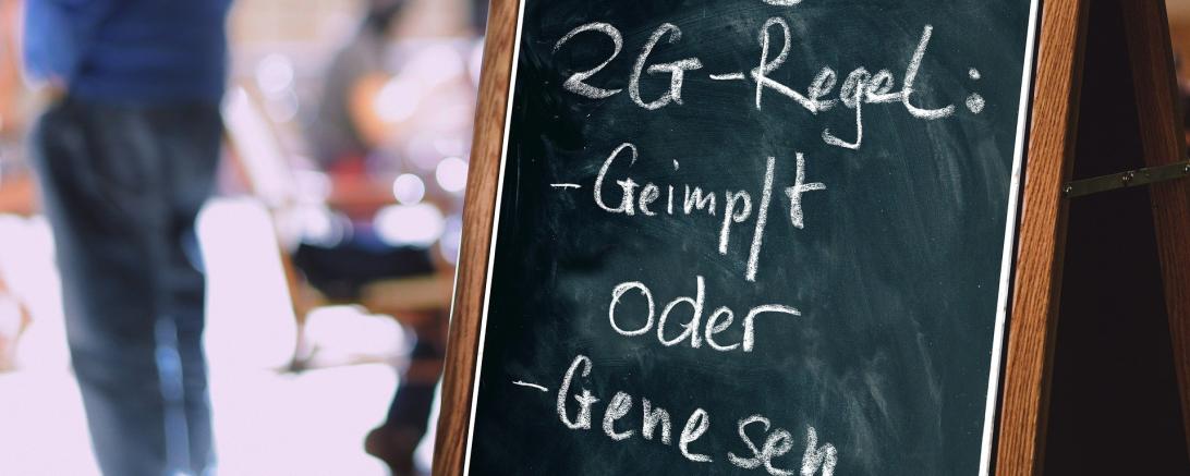 Tafel mit Kreide beschrieben: Hier gilt 2G-Regel: Geimpft oder Genesen