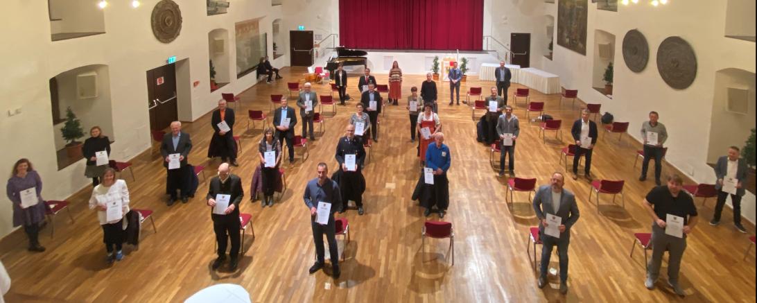 Menschen mit Urkunden stehen in Stadtsaal Klösterle