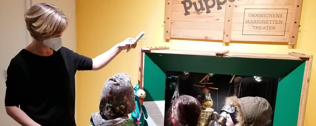 Im Bild zu sehen: Kristina Wnuk, zuständig für Museumspädagogik und Führungen für Kinder, mit den kreativ Kids im Puppenmuseum. 