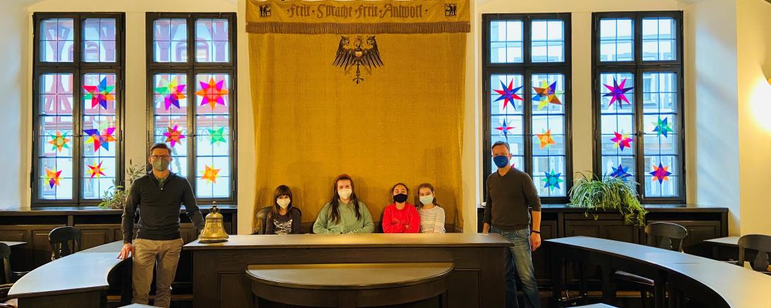 Die kleinen Künstlerinnen vom Hort an der Hans-Schäufelin-Schule haben ihre Sterne im Sitzungssaal im Rathaus selbst aufgehängt (v.l.: Oberbürgermeister David Wittner, Svenja, Lisa, Beren, Elena, Martin Wiedemann (Leiter Hort an der Hans-Schäufelin-Schule)).