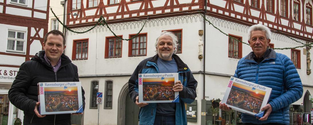 Daniel Wizinger (Tourist-Information), Jürgen Möhnle (Spielwaren Möhnle) und Peter Hueber (Foto Finck). mit Nördlingen-Puzzle von Ravensburger