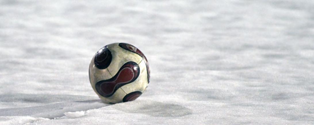 Auf dem Bild sieht man einen Ball im Schnee.