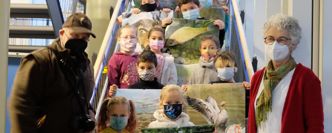 Hegeringleiter Otto Wippich und Jägervorsitzender Robert Oberfrank, sowie Jagdhündin Bonnie waren zur Kalenderübergabe an der Johannes-Bayer-Grundschule in Rain.