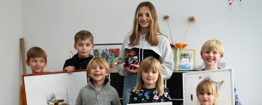Auf dem Bild freuen sich die Lions-Kinder über die Kunstwerke und die Unterstützung für Klasse2000. 