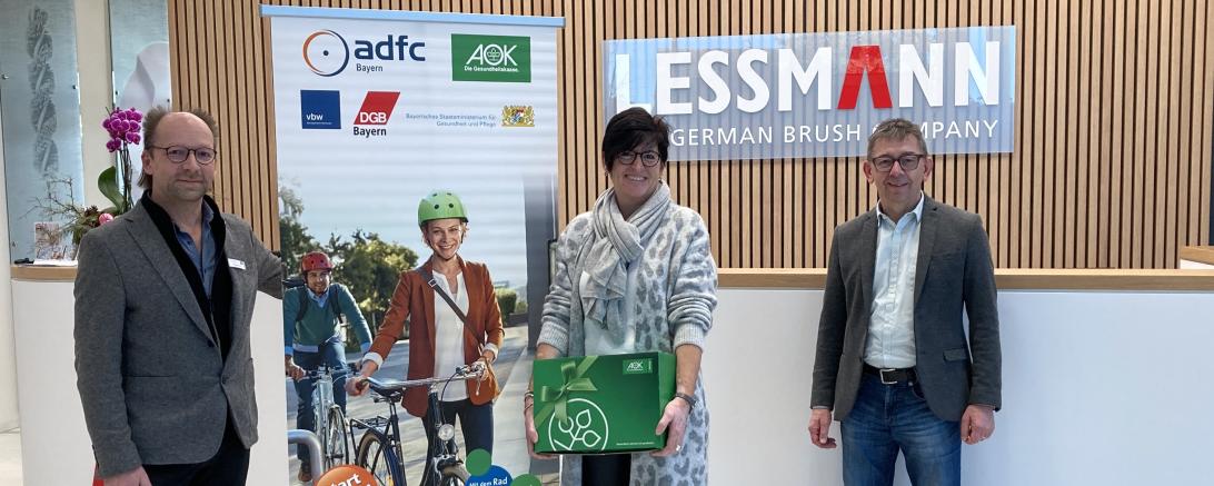 AOK-Firmenkundenberater Oliver Weber (links) und Lessmann Geschäftsführer Dieter Lessmann (rechts) freuen sich den Gewinn an Roswitha Schneele übergeben zu dürfen.	