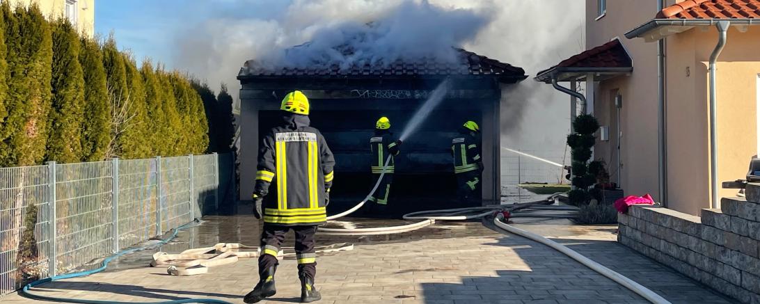 Feuerwehrleute im Einsatz bei brennender Garage 