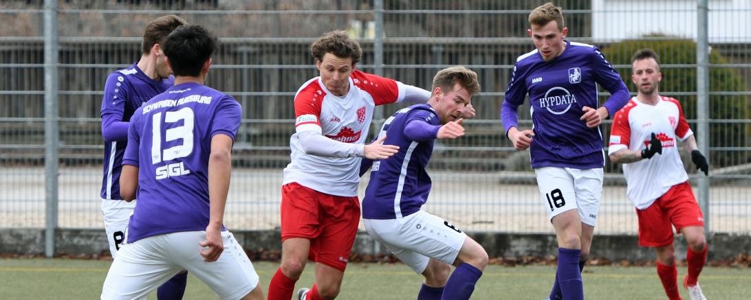 Johannes Müller (m.) im Zweikampf gegen den TSV Schwaben Augsburg. Im Hintergrund Neuzugang Angelo Mayer, der auf seine ersten Minuten im Trikot des TSV Rain kam. 