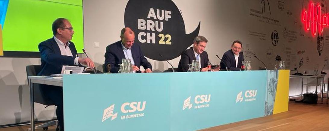 Das Bild zeigt Ulrich Lange, Friedrich Merz, Markus Söder und Alexander Dobrindt am Podium