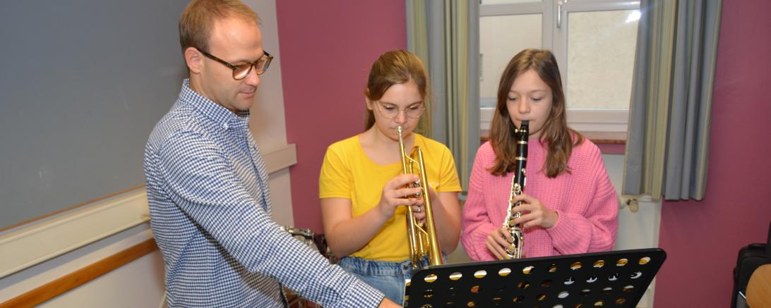 Das Bild zeigt Musiklehrer Tobias Freißler unterrichtend die Bläserklasse an der Realschule St. Ursula.