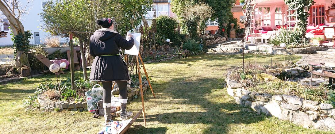 Frau malt in einem Garten in Harburg
