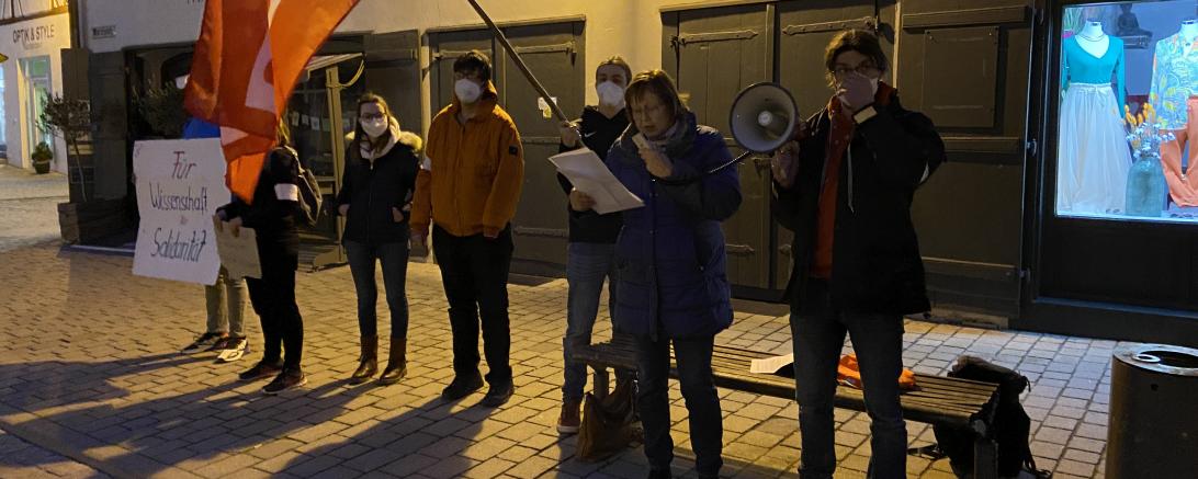 Gabriele Fograscher verliest Rede, daneben Jusos mit Flagge