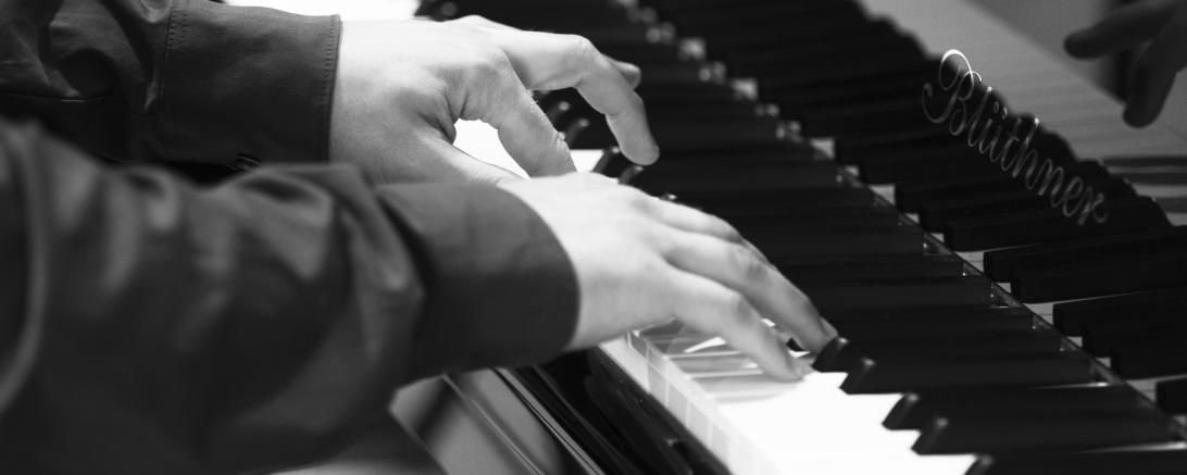 Das Bild zeigt eine Person beim Klavier spielen