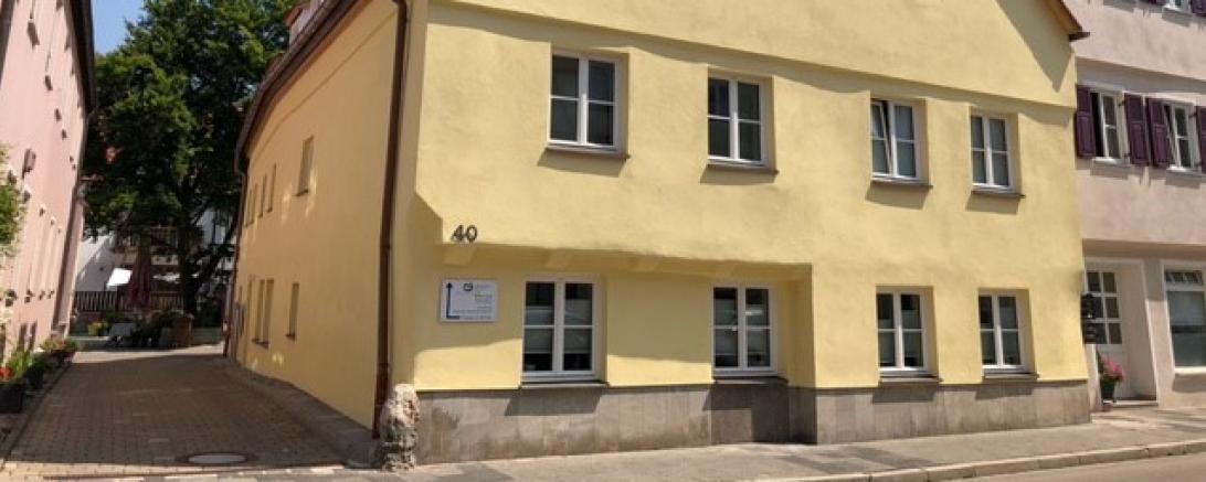 Das Foto zeigt das große Wohnhaus, in dem die WG im ersten Stock zuhause ist.