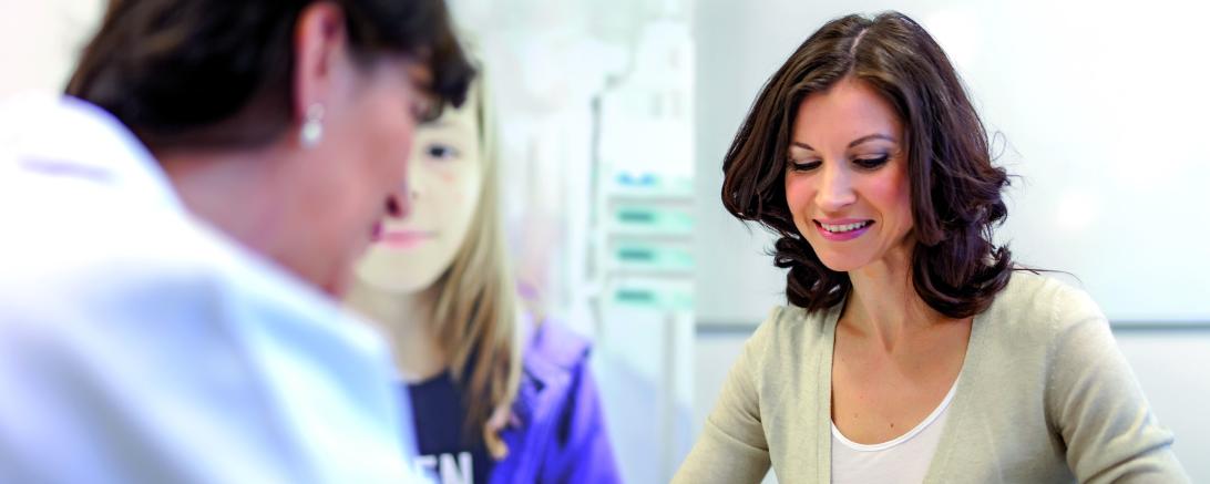 Das Bild zeigt eine Frau beim Arztgespräch