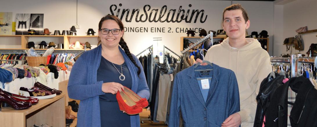 Das Bild zeigt Sandra Mayr, Projektleitung im SinnSalabim und Mitarbeiter Andreas Uhl mitten im Second Hand Kaufhaus.