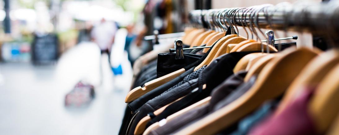 Zu sehen ist Kleidung, die auf Kleiderbügel aufgehängt ist.