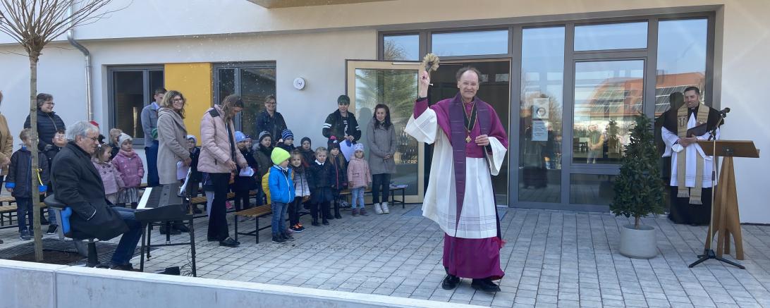 Domdekan Dr. Wolfgang Hacker verteilt Weihwasser vor neuer Kita St. Michael