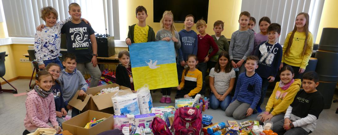 Das Bild zeigt die Grundschulkinder mit den Spenden.