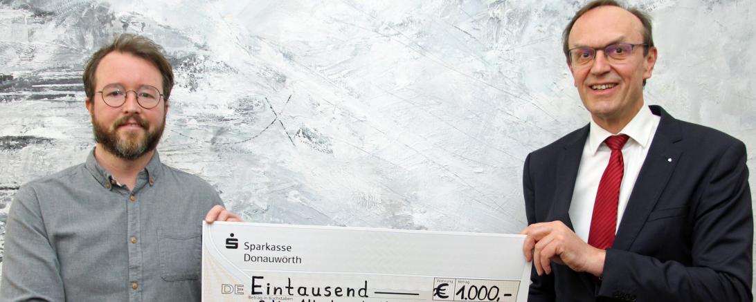 Das Bild zeigt Achim Zinsmeister und Sparkassendirektor Johann Natzer bei der Scheckübergabe.