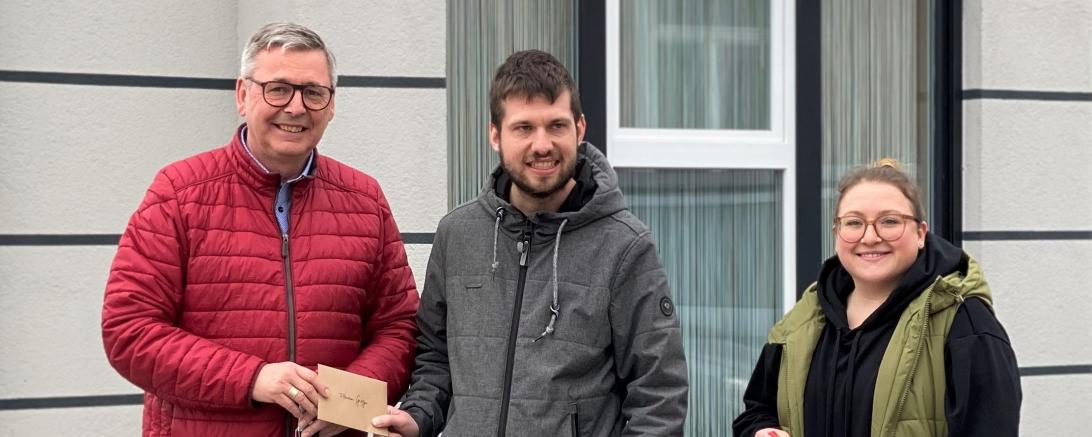 Zu sehen sind Gerhard Wiedemann, Florian Gröger und Victoria Bauer bei der Übergabe des Gutscheines. 
