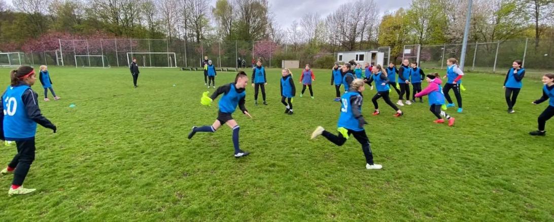 Zu sehen sind eine Gruppe Mädchen während einem Fußballspiel. 