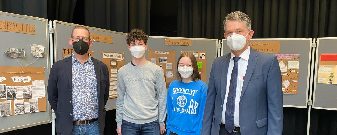 Zu sehen sind Ulrich Fritz, Luis Stegmüller, Frau Julia Förg und Markus Edenhofer vor Ausstellungstafeln. 