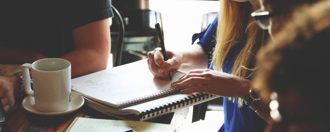 Jugendliche lernen mit Block und Laptop