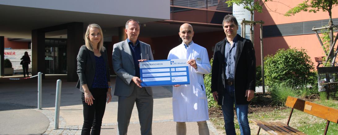 Zu sehen sind Mareike Baumann, Jürgen Neumann, Dr. Thomas Klaus Schmitt und Helmut Gerstmeier bei der Spendenübergabe vor dem Stiftungskrankenhaus. 